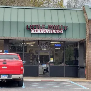 a red truck parked in front of the store
