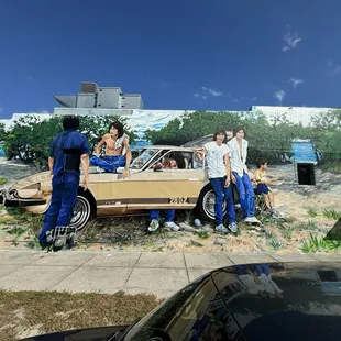 Mural outside of restaurant includes outdoor picnic tables.