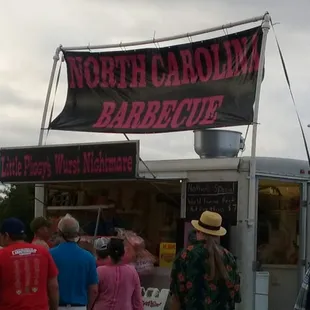 a group of people standing in front of a food truck
