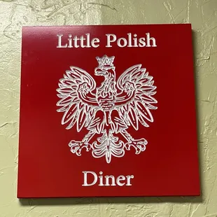 a red sign with a white eagle