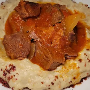 a plate of mashed potatoes and meat