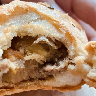 Close up of flaky meat pie crust and stuffing.