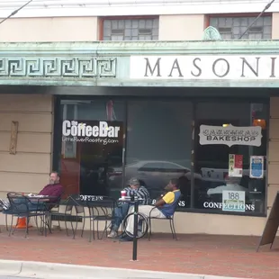 a woman sitting outside of a restaurant