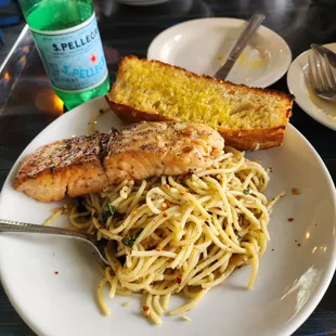 a plate of pasta with chicken and garlic bread