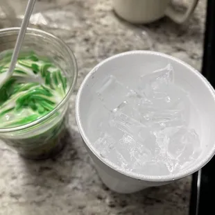 a cup of green slime and a cup of white slime