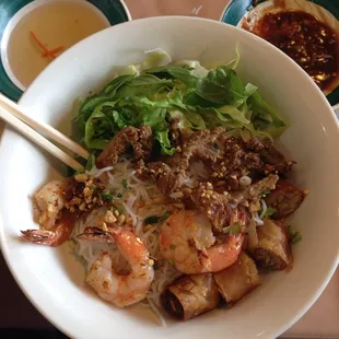 Rice noodle bowl with shrimp, spring roll, and pork