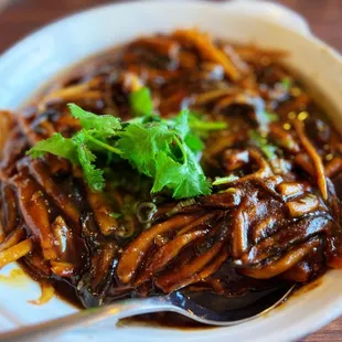 a bowl of noodles and a spoon