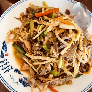 a plate of stir fried beef and vegetables