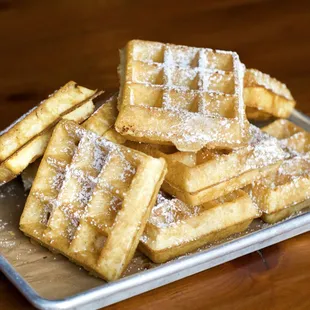 a plate of waffles with powdered sugar on top