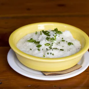 a yellow bowl filled with rice and garnished with parsley