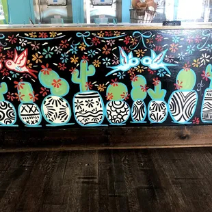 a colorful mural of birds, flowers, and cacti