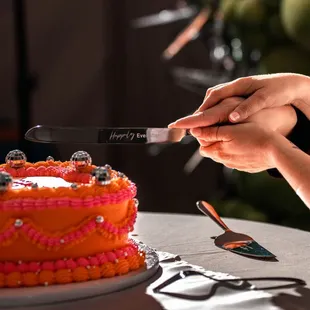 Couple cutting their disco, vintage-styled orange and pink wedding cake