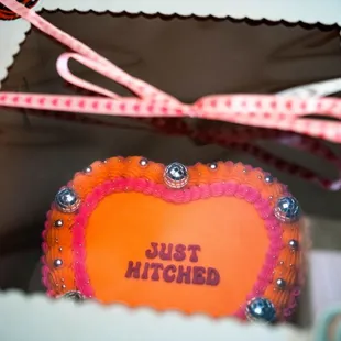 Neon Orange and pink vintage-style, fun, disco wedding cake that says Just Hitched - made by Little Sugar Crumb Sweets
