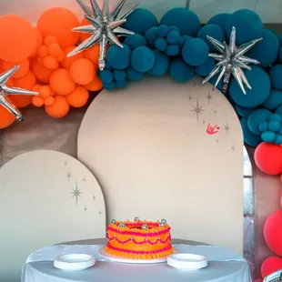 Orange and pink vintage-style wedding cake that says Just Hitched with disco balls for decoration at El Pais Motel in Tucson, Arizona