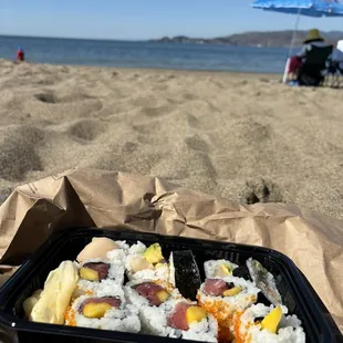 a tray of sushi on the beach