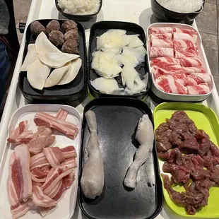 White rice, beef balls, dumplings, pork belly, scallops, frog legs, noodles, beef/lamb, marinated beef  (From top left down)