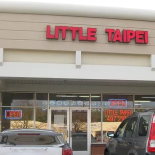 two cars parked in front of the store