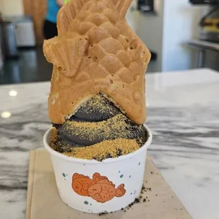 October black cake batter ice cream with graham cracker crumbs topped with a custard-filled taiyaki