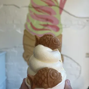 a hand holding a cup of ice cream