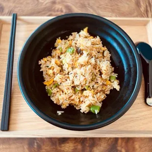 a bowl of fried rice with chopsticks