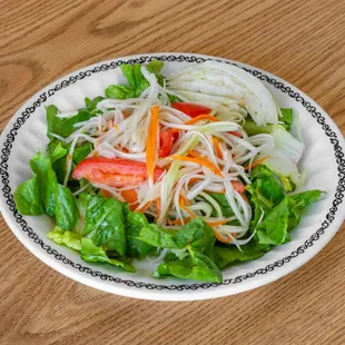 a plate of salad on a wooden table