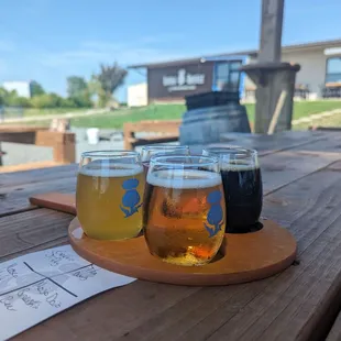 a flight of beers on a wooden table