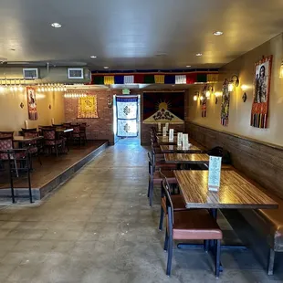 the inside of a restaurant with tables and benches