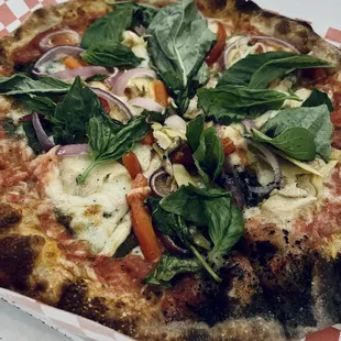 Garden pizza loaded with veggies and basil.