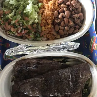 Carne Asada over grilled onions peppers and jalapeños guac, pico and ranchero beans.