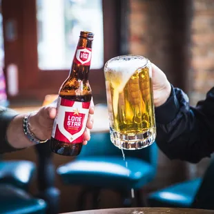 a man holding a beer and a woman holding a glass of beer