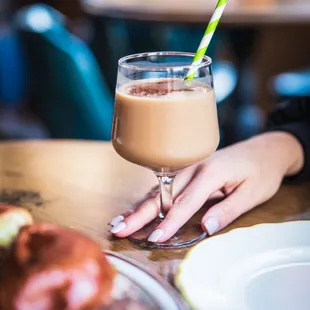 a woman holding a glass of coffee