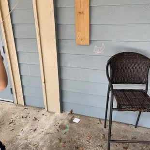 a wicker chair and a wooden sign