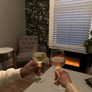 two people toasting with wine glasses
