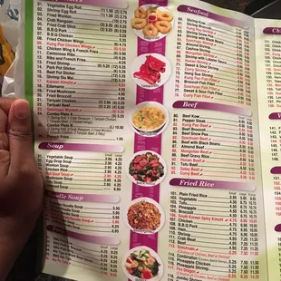 a person holding a menu in their hand