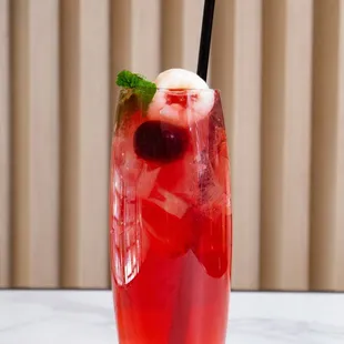 a red drink with a straw and mint