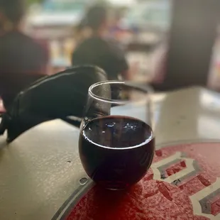 a glass of red wine on a table