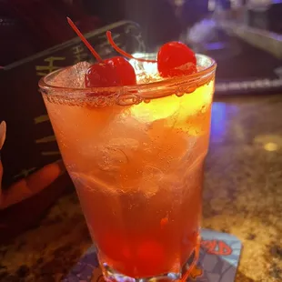 a drink with a cherry garnish
