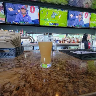 a glass of beer on a bar