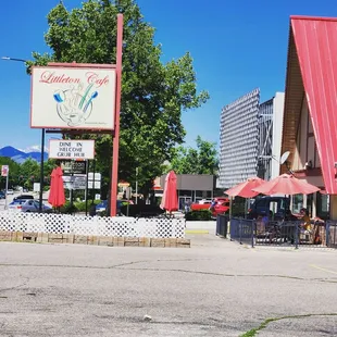 an empty parking lot with tables and umbrellas
