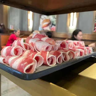 a tray of raw meat wrapped in bacon