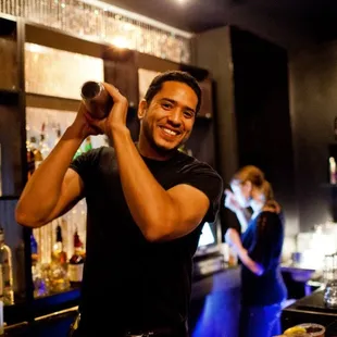 a man making a drink at a bar