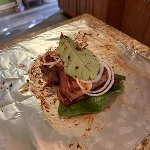 Marinating and topping with onions and avocado leaves