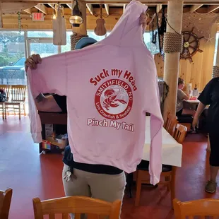 a man holding a pink hoodie