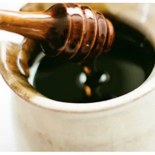a honey being poured into a cup