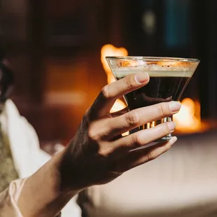 a woman holding a glass of coffee