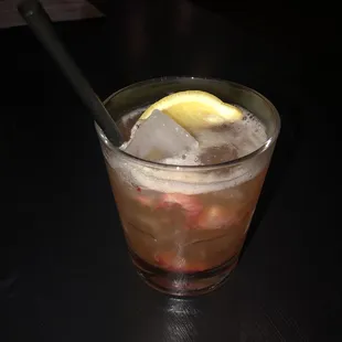 a drink with ice and lemon wedge