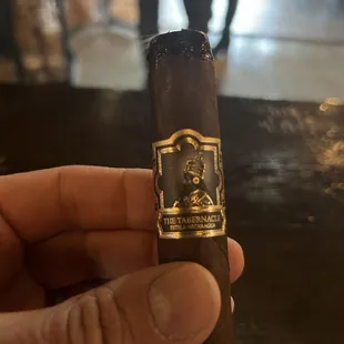 a hand holding a cigar