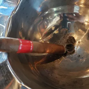 a cigar in a silver bowl