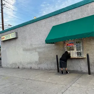 a person sitting at a table in front of a store