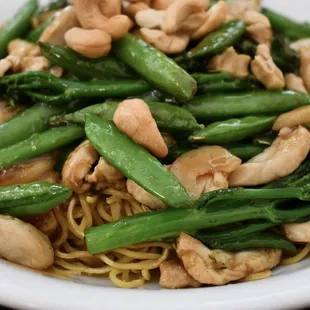 a plate of noodles with asparagus and cashews